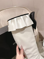 Chanel white knee-high boot with ruffled cuff and black ribbon bow at top