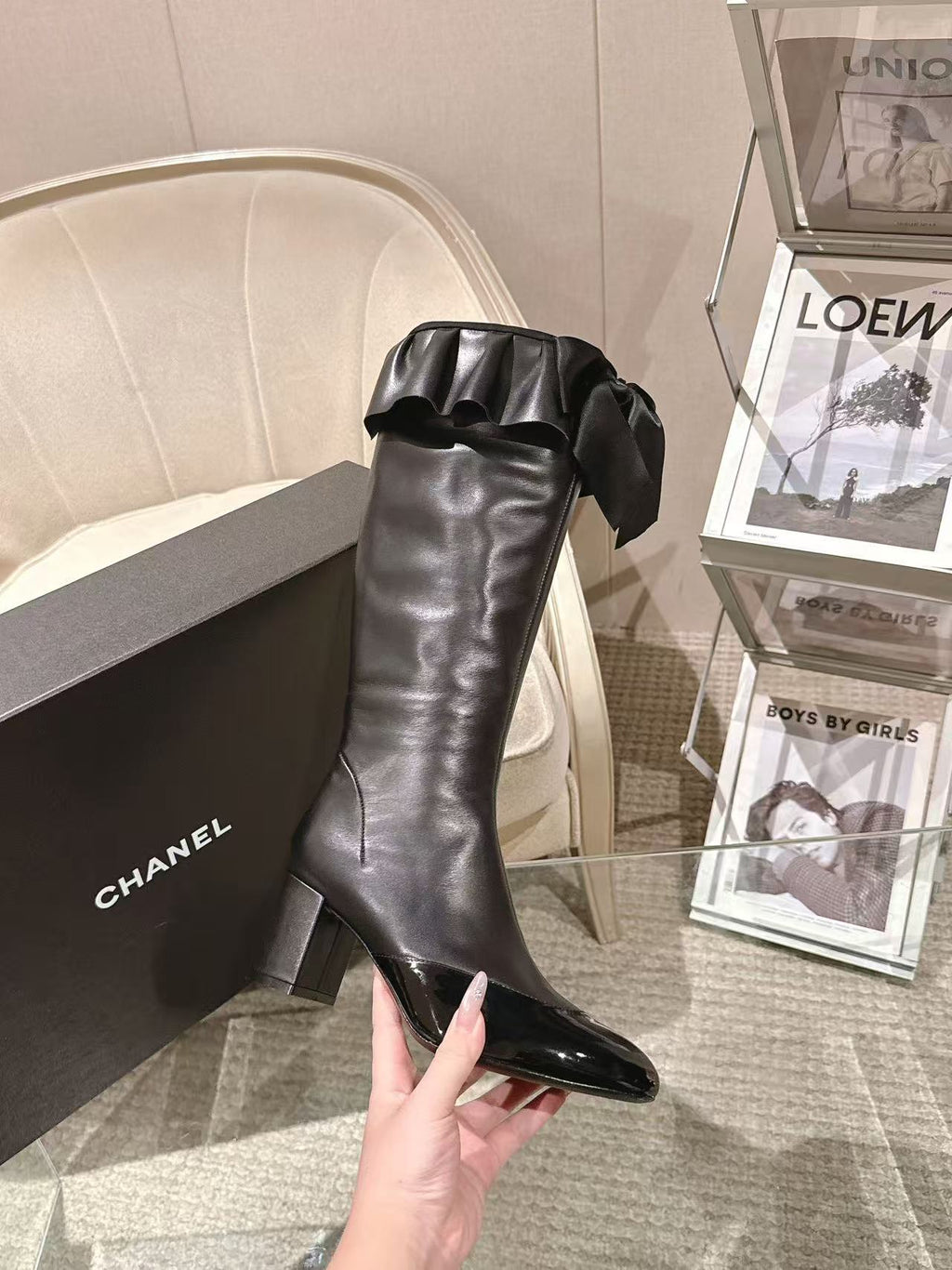 Black knee-high leather boot with chunky heel and ruffled top bow