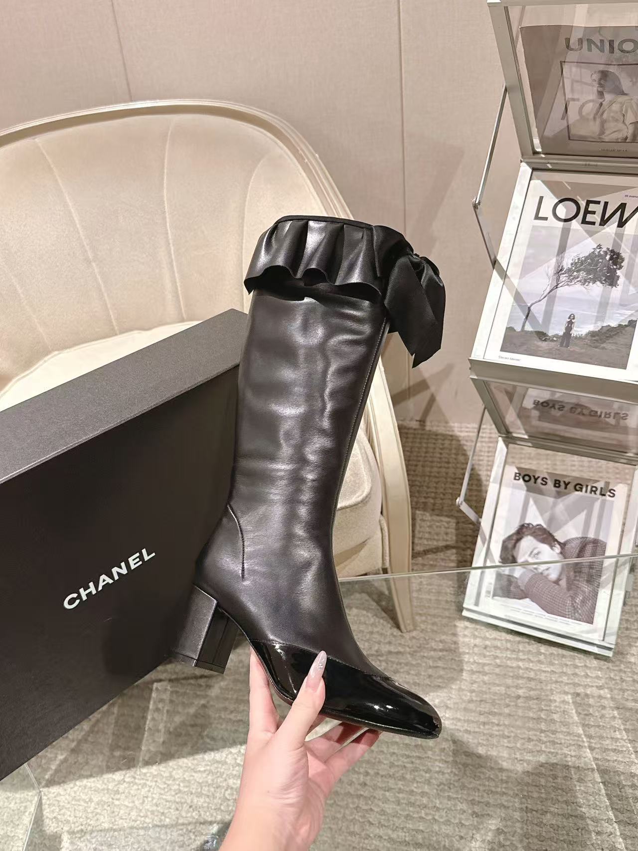 Black knee-high leather boot with chunky heel and ruffled top bow