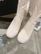 Pair of Chanel light white knee-high boots with embossed logo on toe