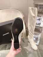 Chanel knee-high boot sole shown in hand, light white leather upper