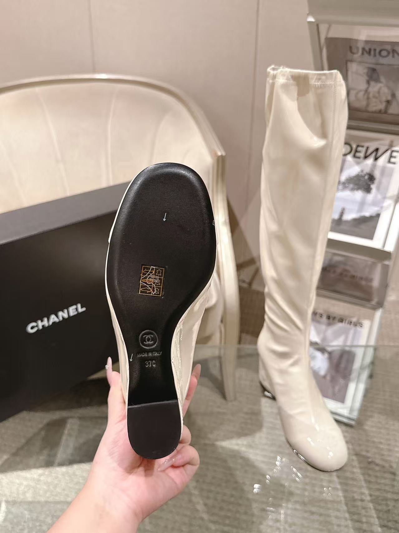 Chanel knee-high boot sole shown in hand, light white leather upper