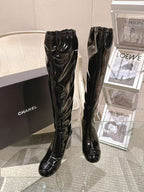 Chanel black patent leather knee-high boots, front view with pointed toe
