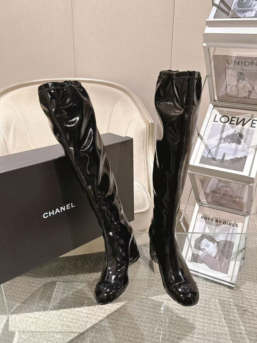 Chanel black patent leather knee-high boots, angled front view with slim heel