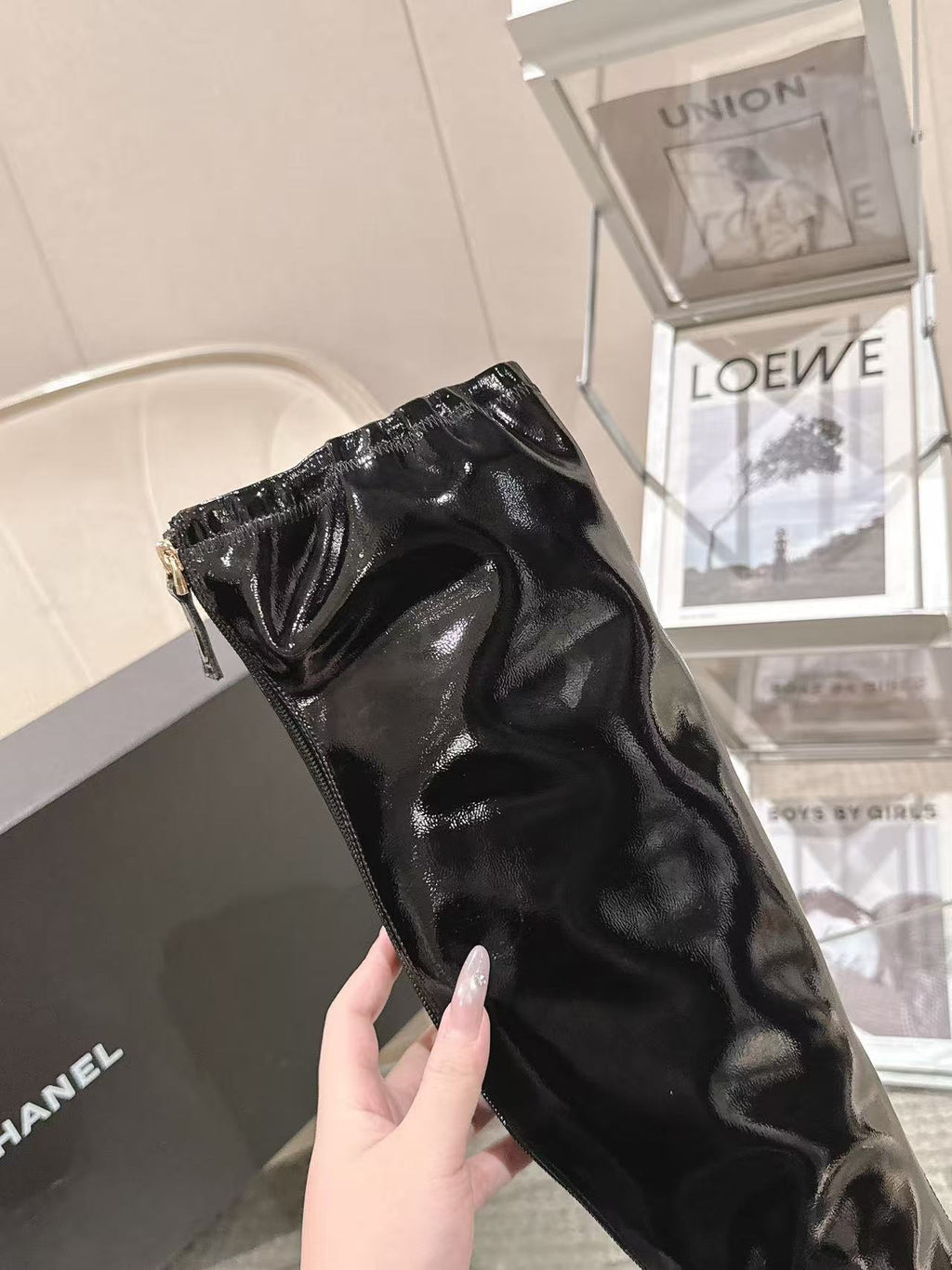 Chanel black patent leather knee-high boot, close-up of glossy upper and heel