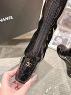 Chanel black patent leather knee-high boot, close-up of zipper and logo patch