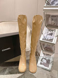 Chanel glossy beige knee-high boots with slim heel, full pair view