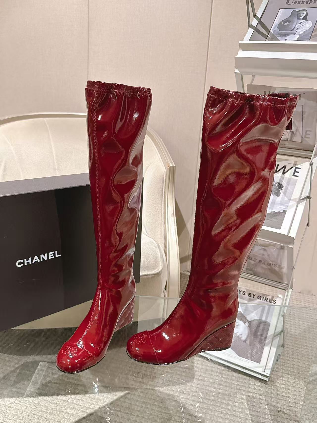Red patent leather knee boots with pointed toe and stacked heel