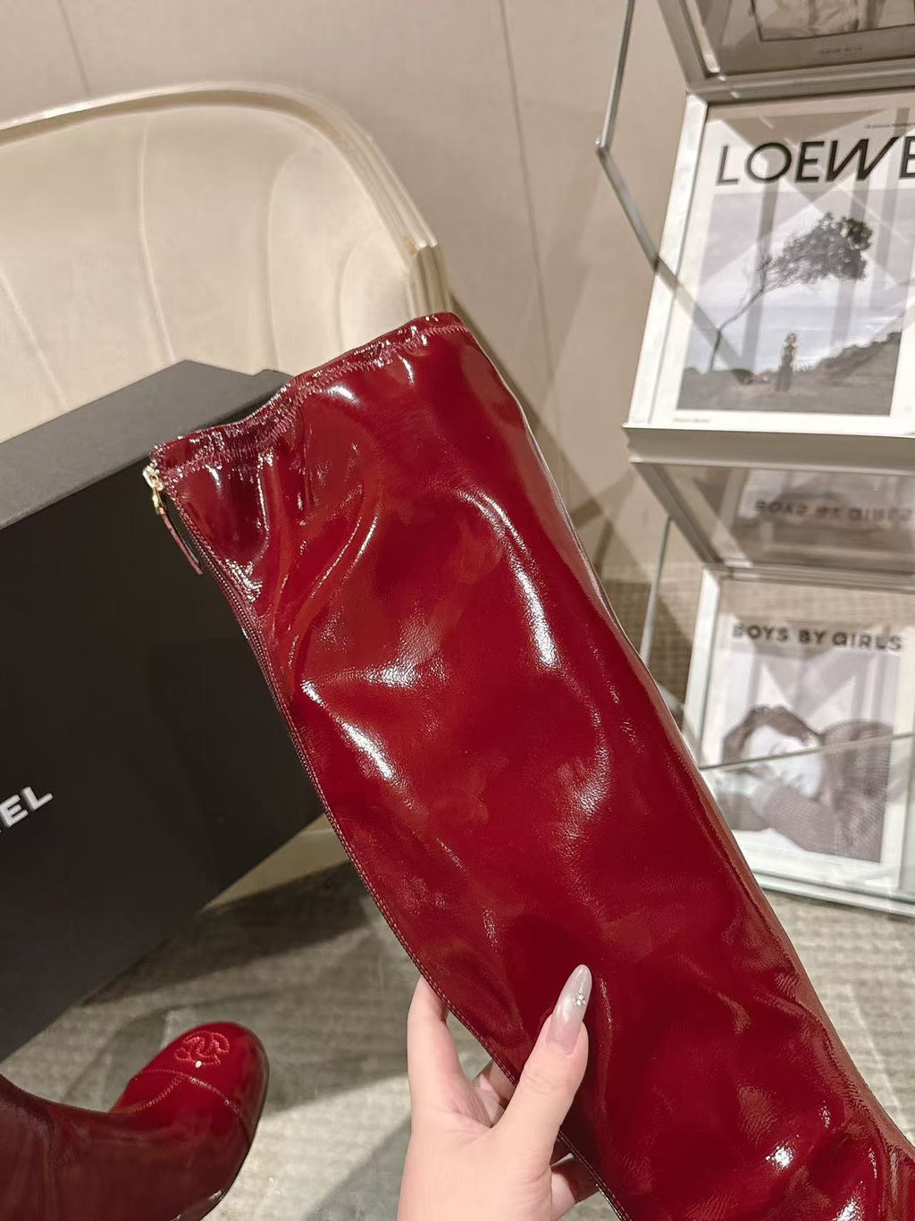 Red patent leather knee boot side view with glossy texture