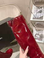 Red patent leather knee boot side view with glossy texture