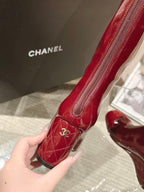 Red patent leather knee boot with zipper and Chanel logo patch