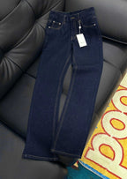 Dark blue denim jeans with gold-trim stitching and embroidered back pockets