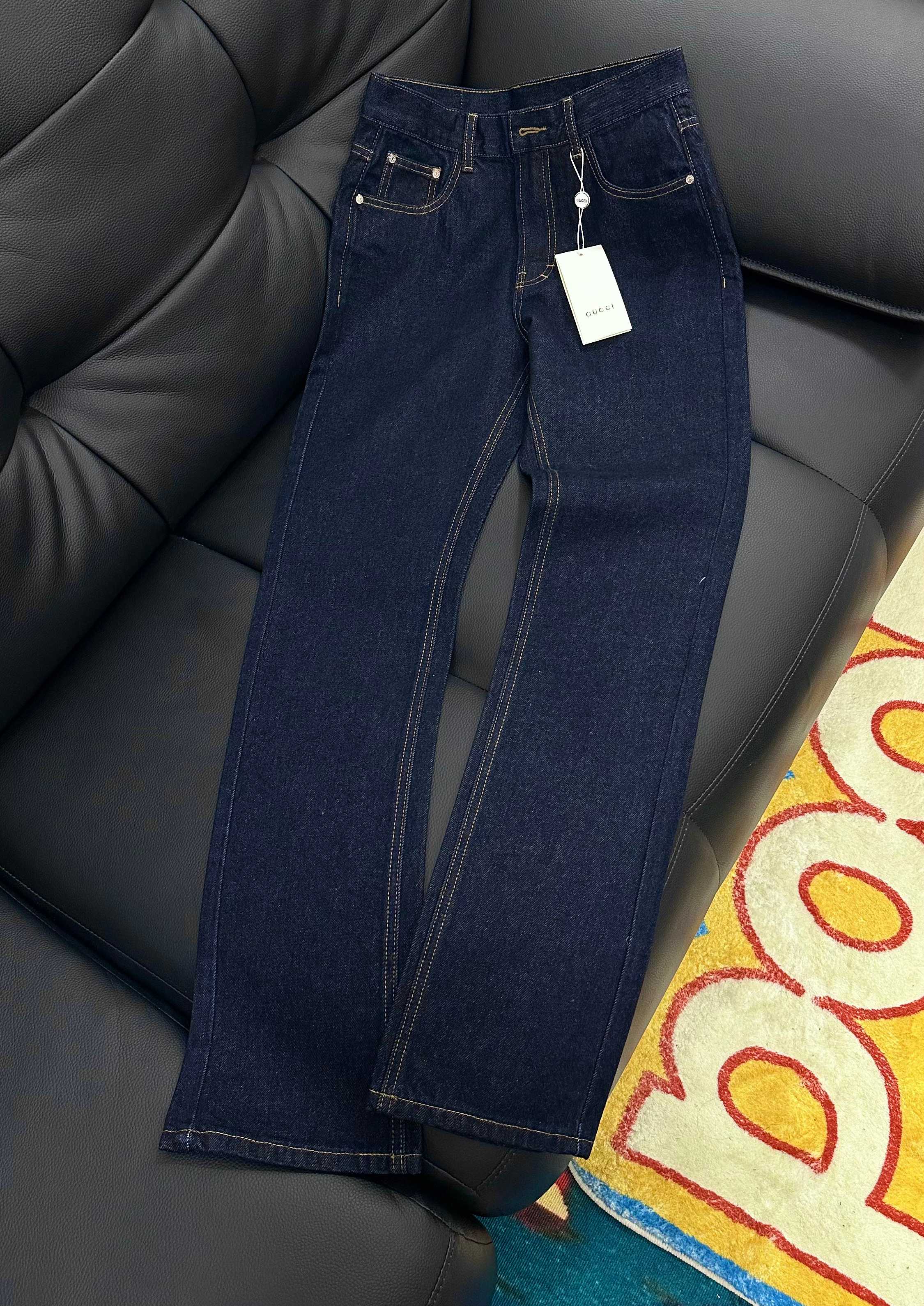 Dark blue denim jeans with gold-trim stitching and embroidered back pockets