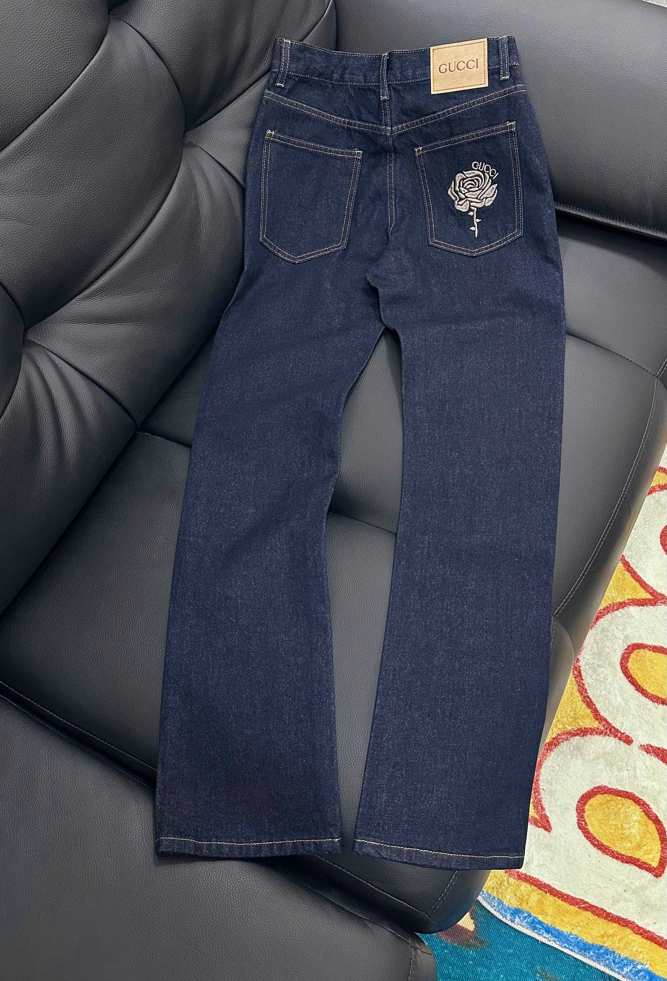 Dark blue denim jeans with rose embroidered back pocket and GUCCI tag