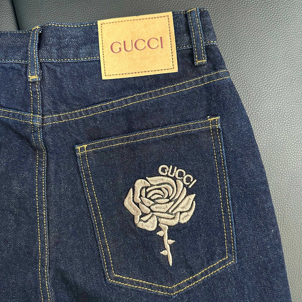 Denim jeans pocket detail with GUCCI label and rose embroidery