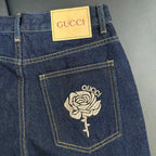 Denim jeans pocket detail with GUCCI label and rose embroidery