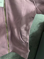 Pink hoodie sleeve cuff and front seam detail near zipper