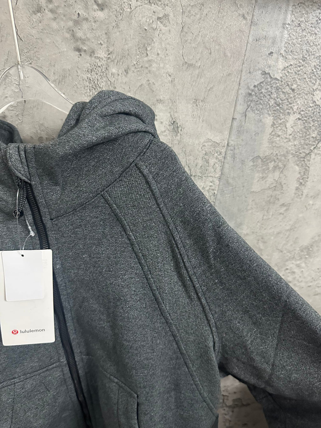 Dark gray hooded sweatshirt with stitched seams and drawstring hood