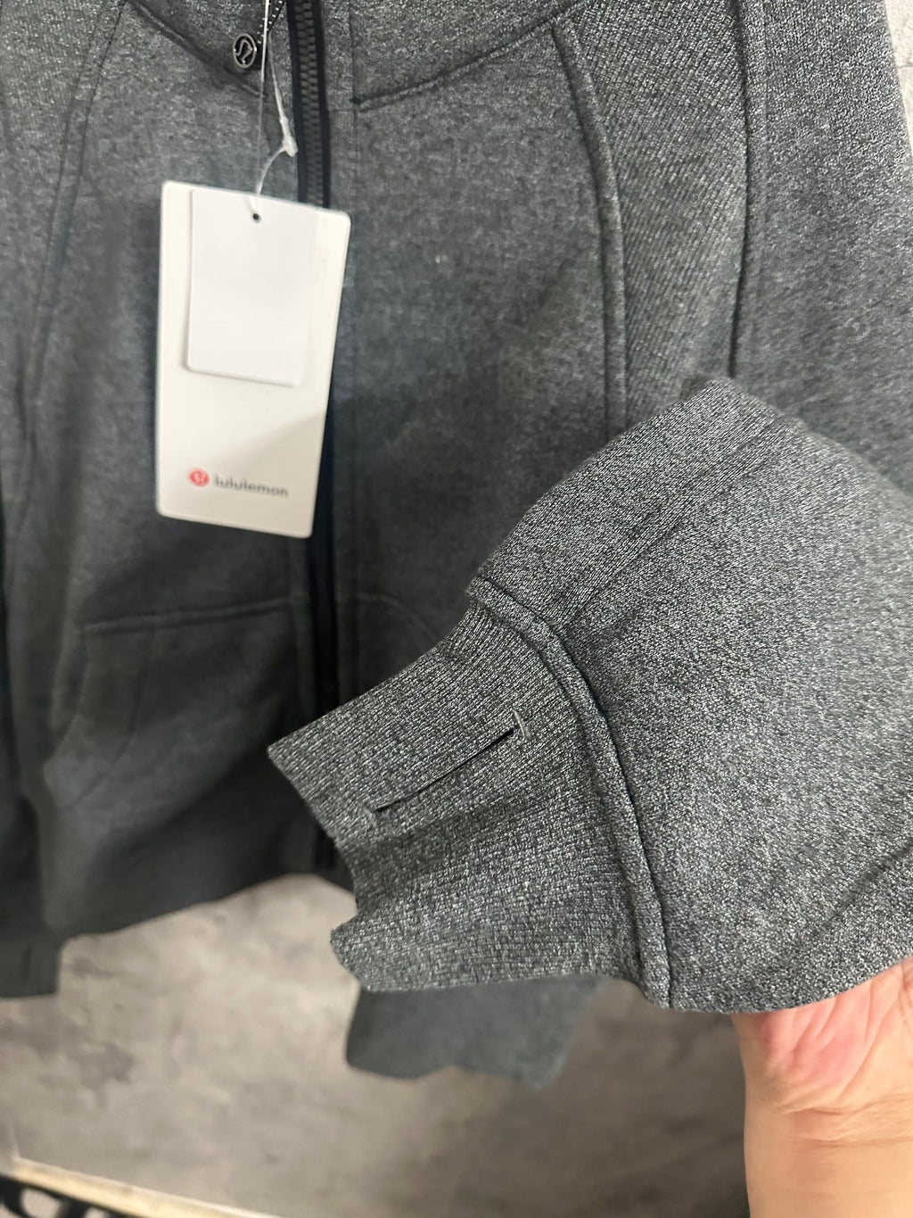 Dark gray zip-up hoodie with hood, front pockets, and ribbed cuffs