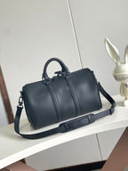 Louis Vuitton barrel bag with top handle, side straps, and long shoulder strap