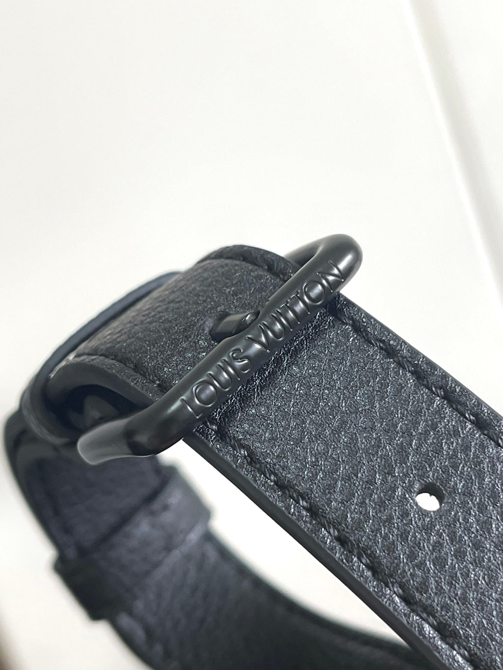 Louis Vuitton bag handle detail with engraved leather pull tab