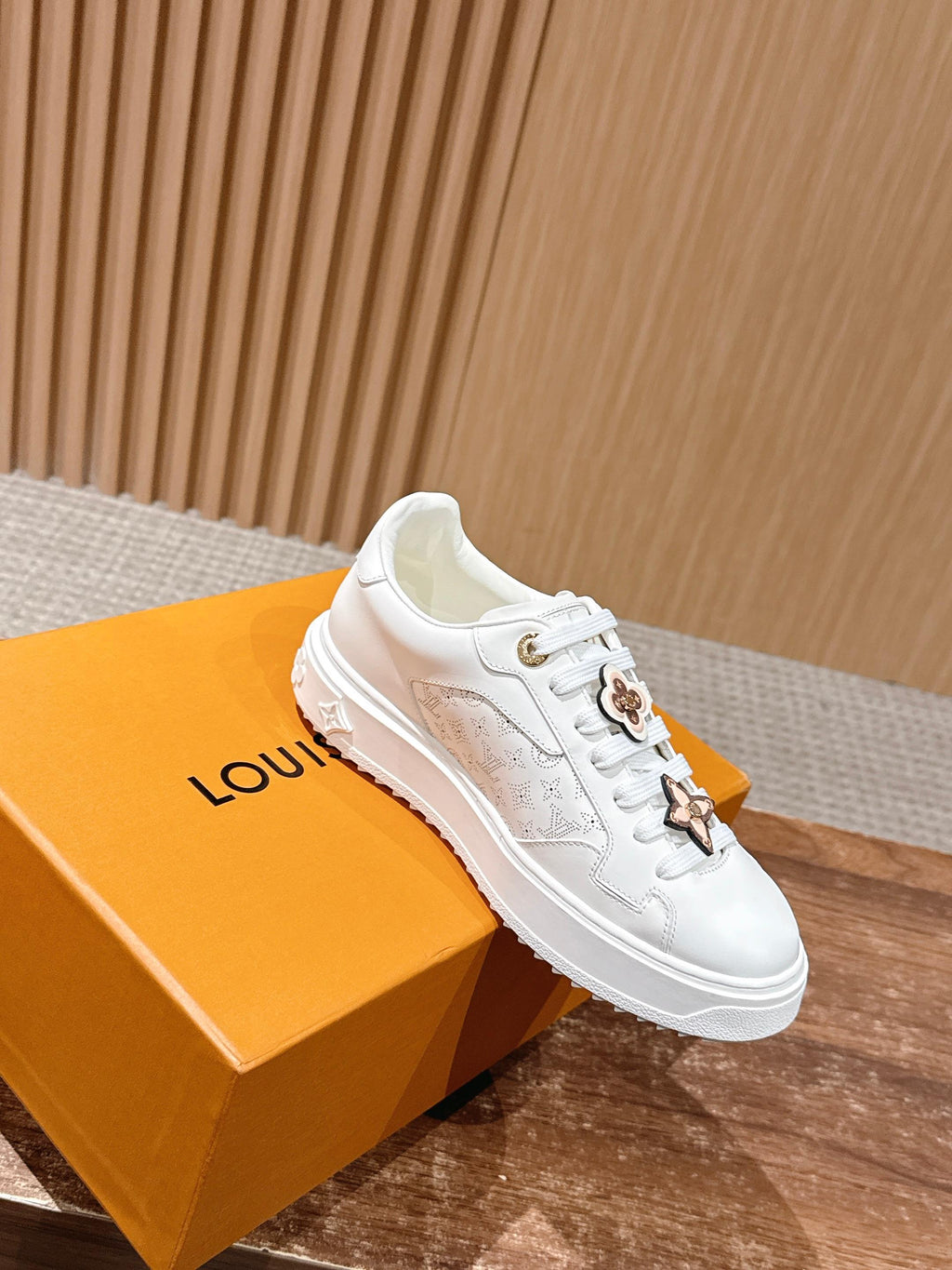 White Louis Vuitton sneakers on box, side angle, gold star detail