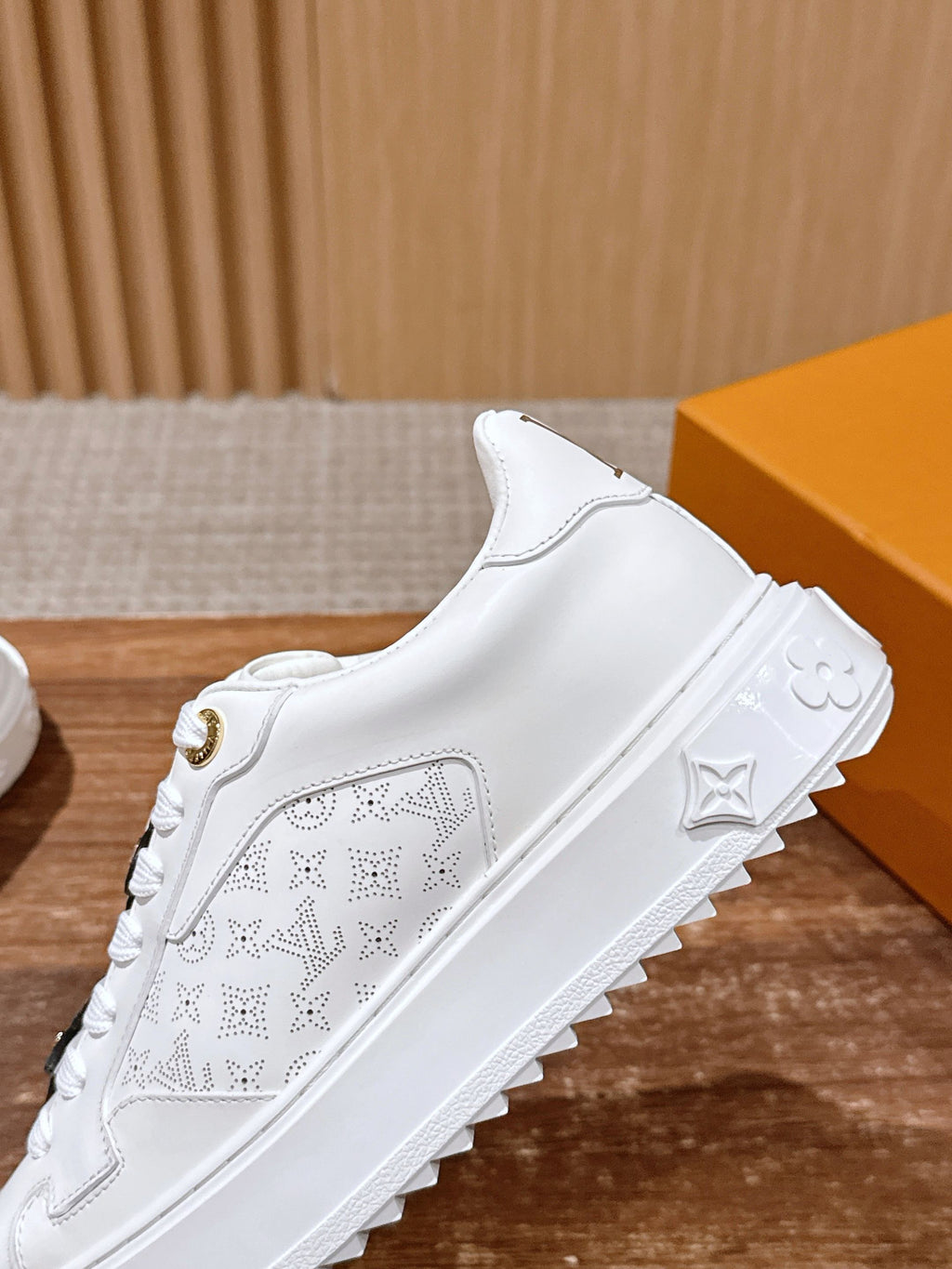 White Louis Vuitton sneakers with perforated logo panel and embossed side design