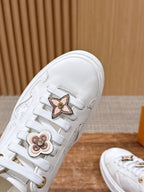 White Louis Vuitton sneaker upper close-up with gold star and flower hardware
