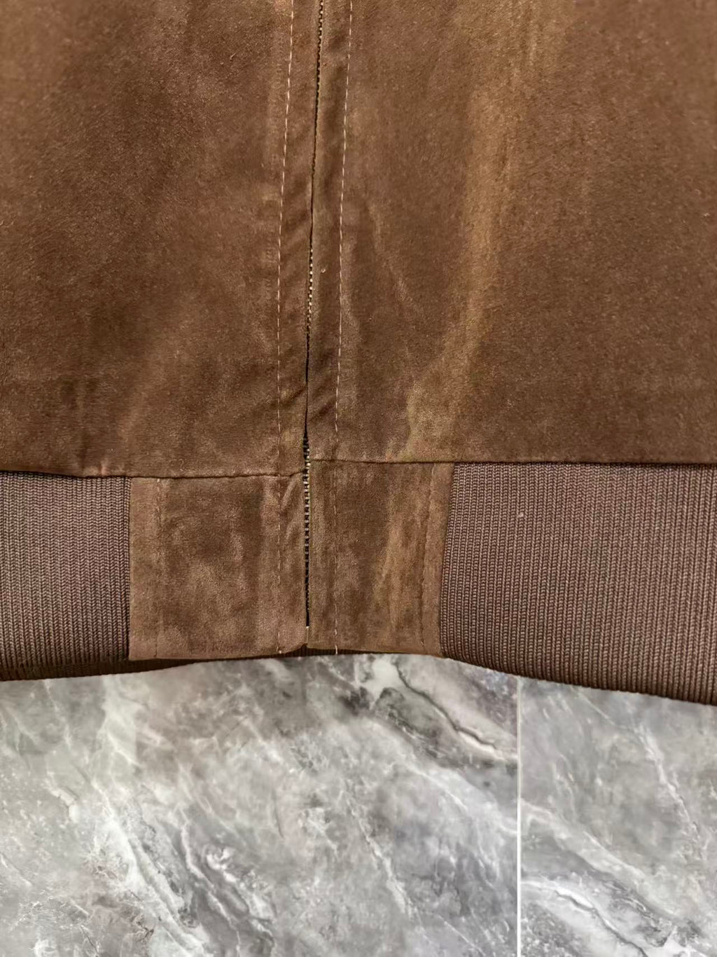 Brown jacket hem with ribbed trim and vertical center zip seam