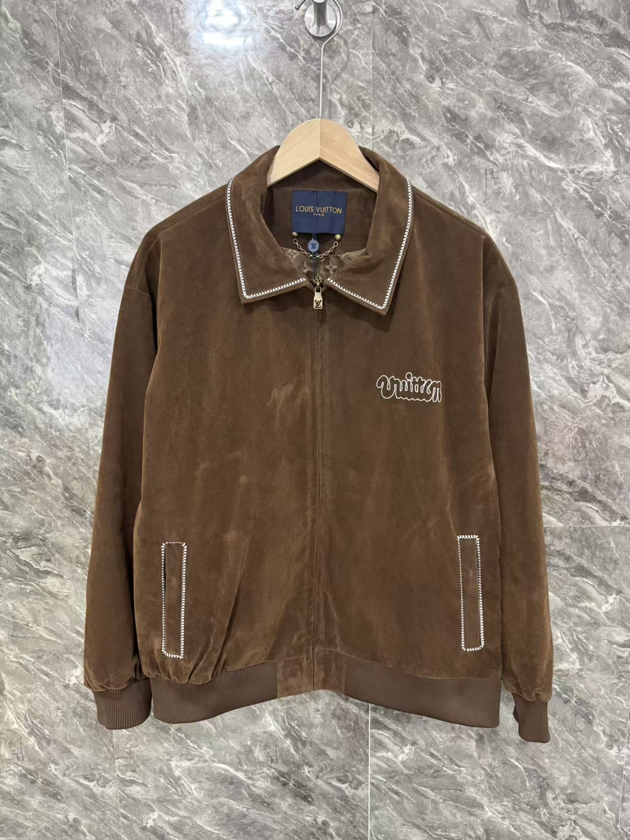 Brown jacket with pointed collar, white-trimmed zipper front, LV logo patch