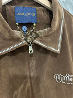 Brown jacket collar with blue interior label, dangling charm and chain detail