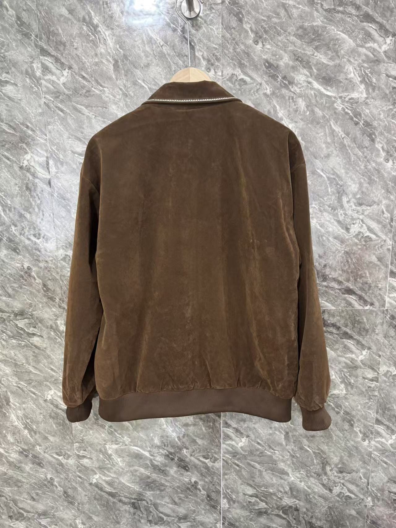 Brown jacket back view with full-length seams and zip closure at hem