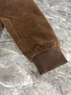 Brown jacket sleeve with ribbed knit cuff and visible seam stitching
