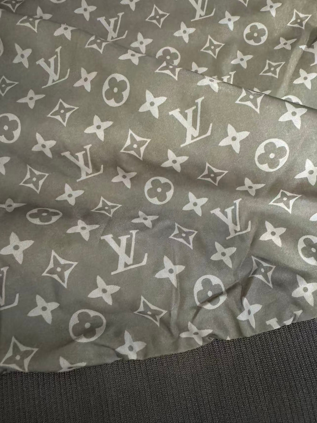 Brown patterned lining with repeating monogram icons and ribbed hem