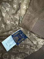 Brown jacket lining with repeating monogram pattern and size label tag