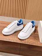 White lace-up sneakers with blue tongue lining and smooth leather panels