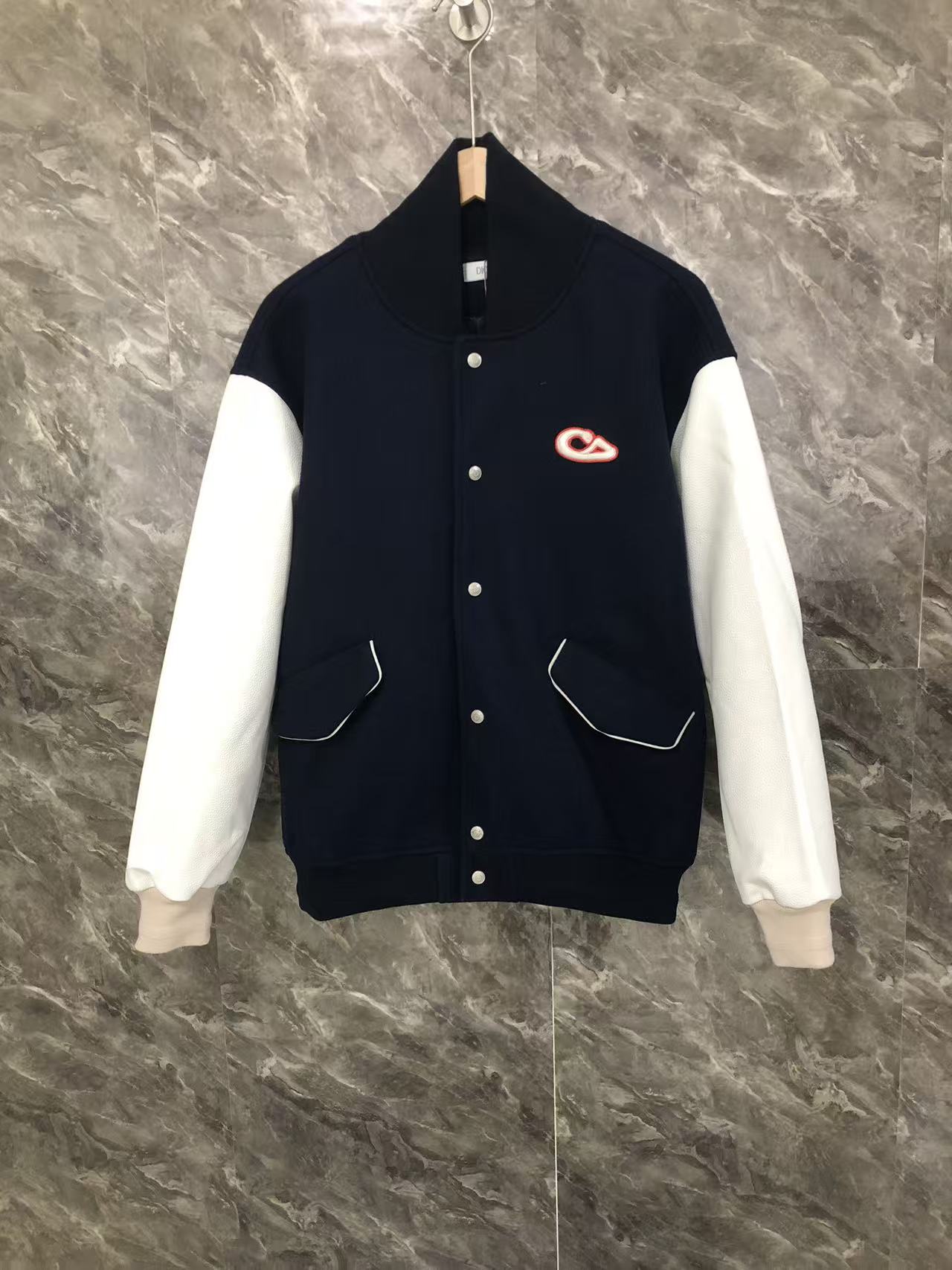 Dior varsity jacket with navy body, white sleeves, button front, and side pockets