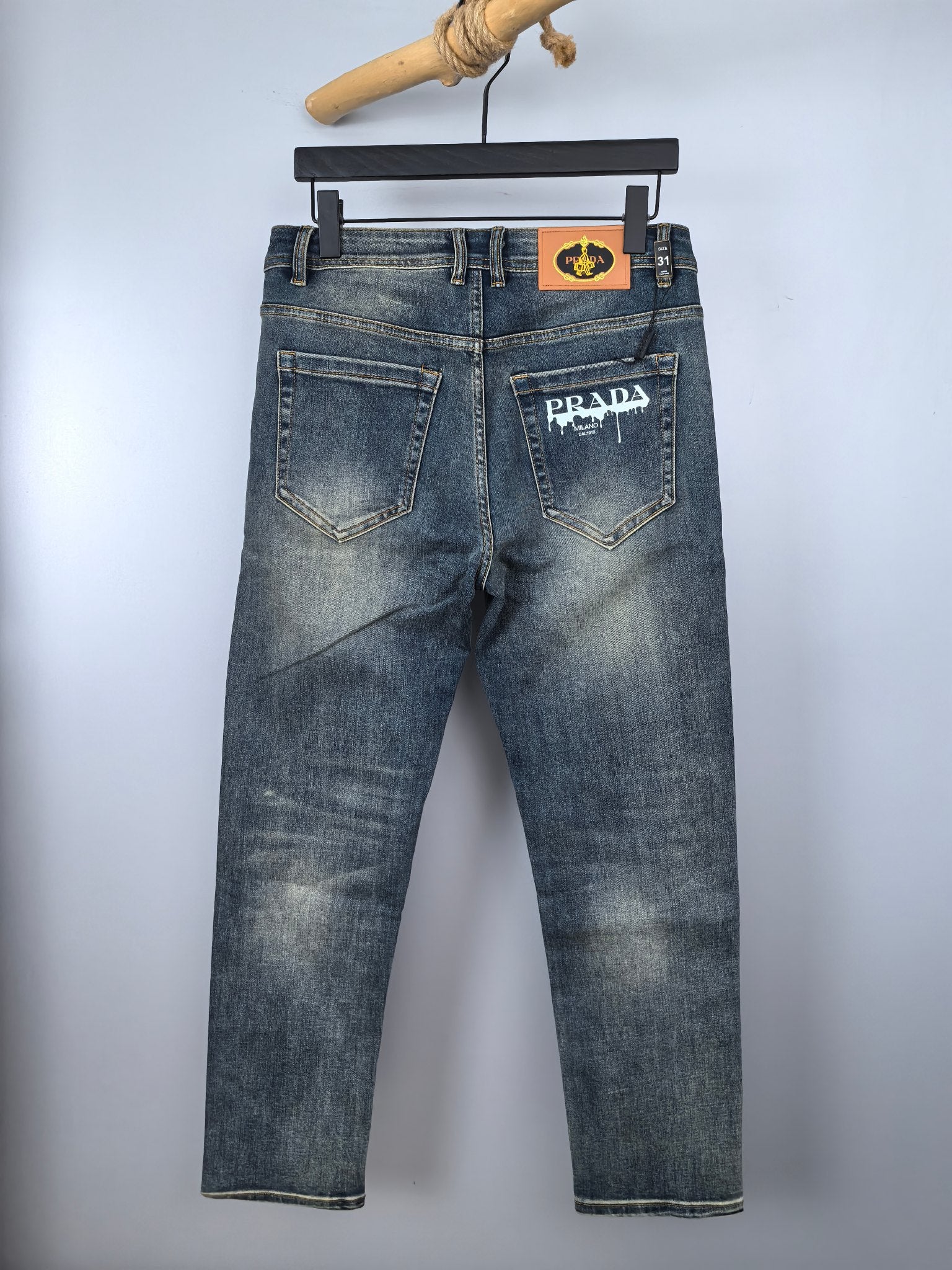 Prada denim pants in light wash blue with back pockets and logo patch