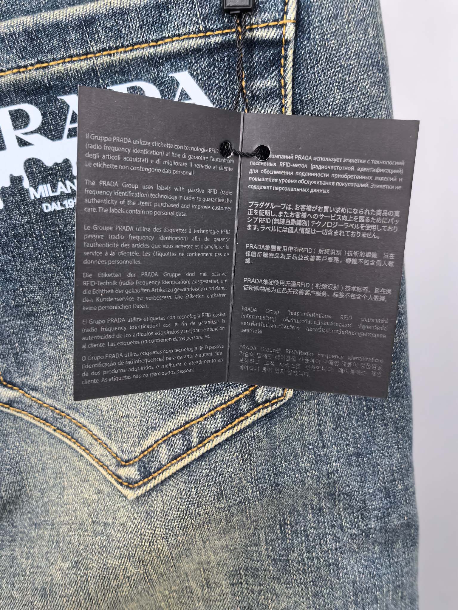 Prada denim pants care instruction tags attached to the waistband