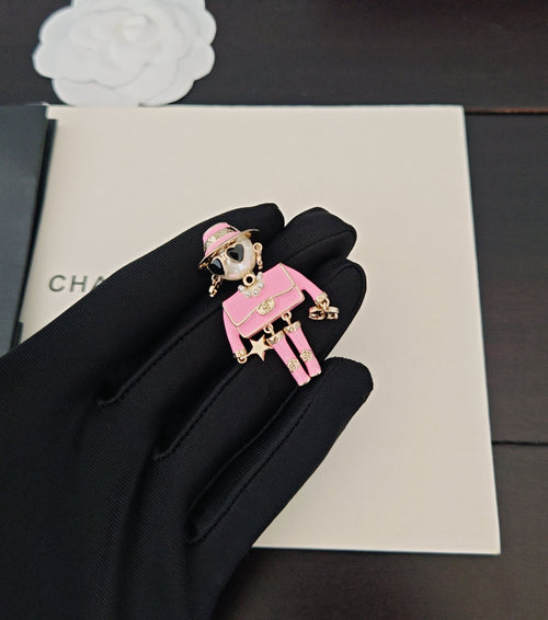 Pink Chanel charm keychain with doll figure and gold-tone hardware
