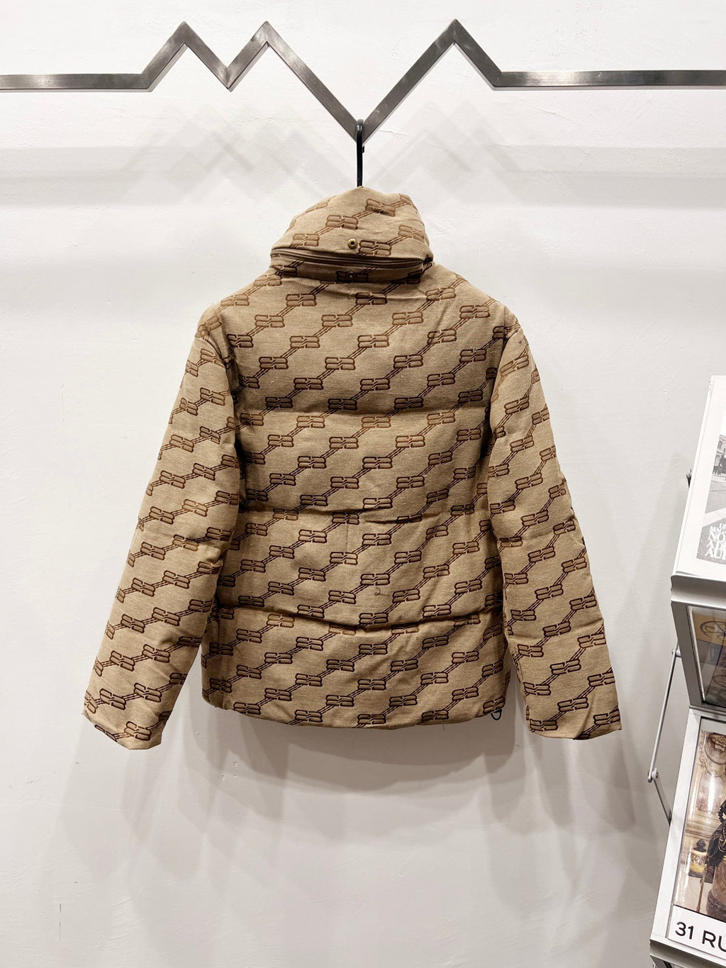 Balenciaga hooded puffer jacket back view in beige with repeating logo pattern