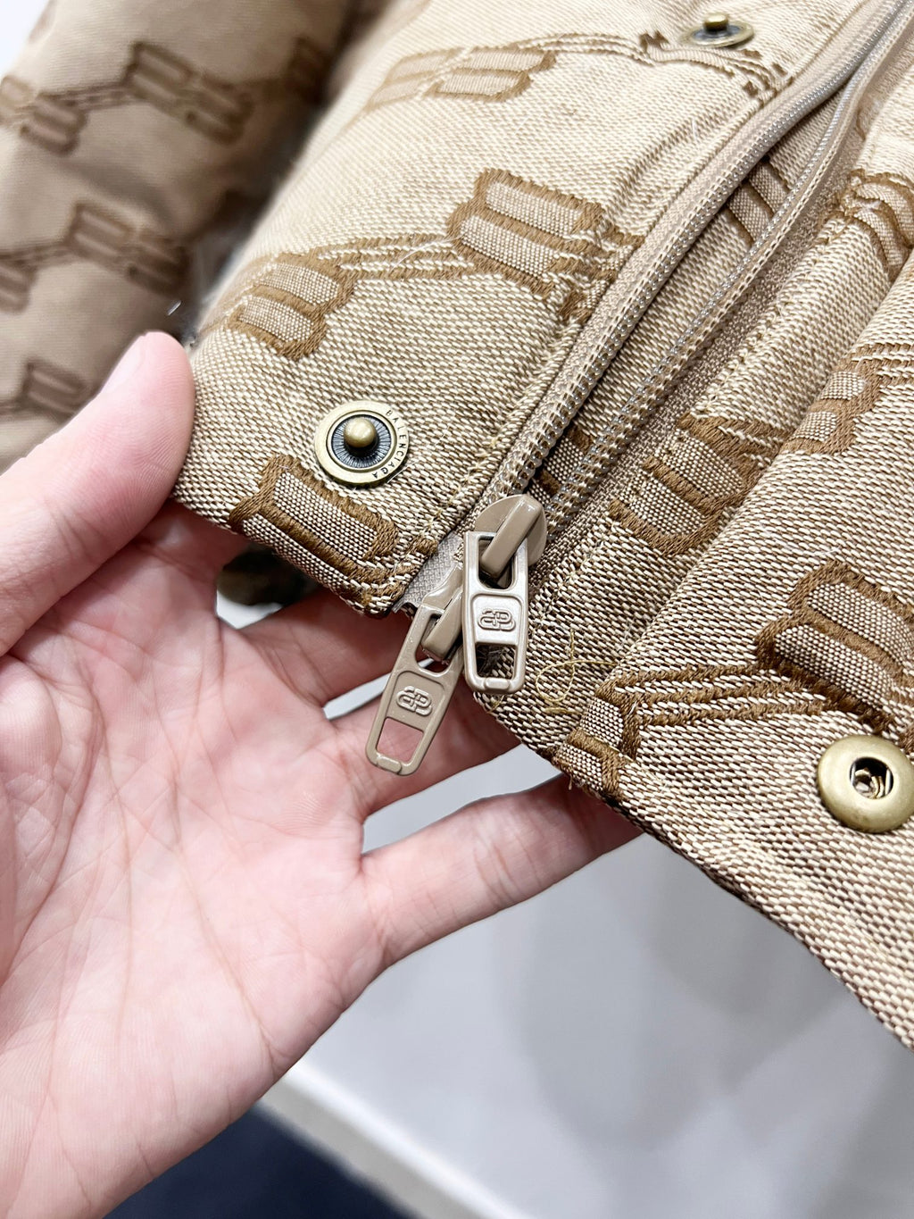 Balenciaga puffer jacket front zipper and snap hardware in beige with logo pattern