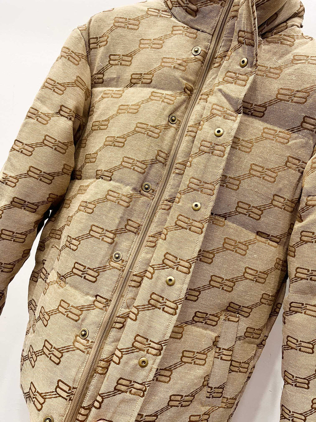 Balenciaga hooded puffer jacket in beige with repeating logo pattern, snap placket details