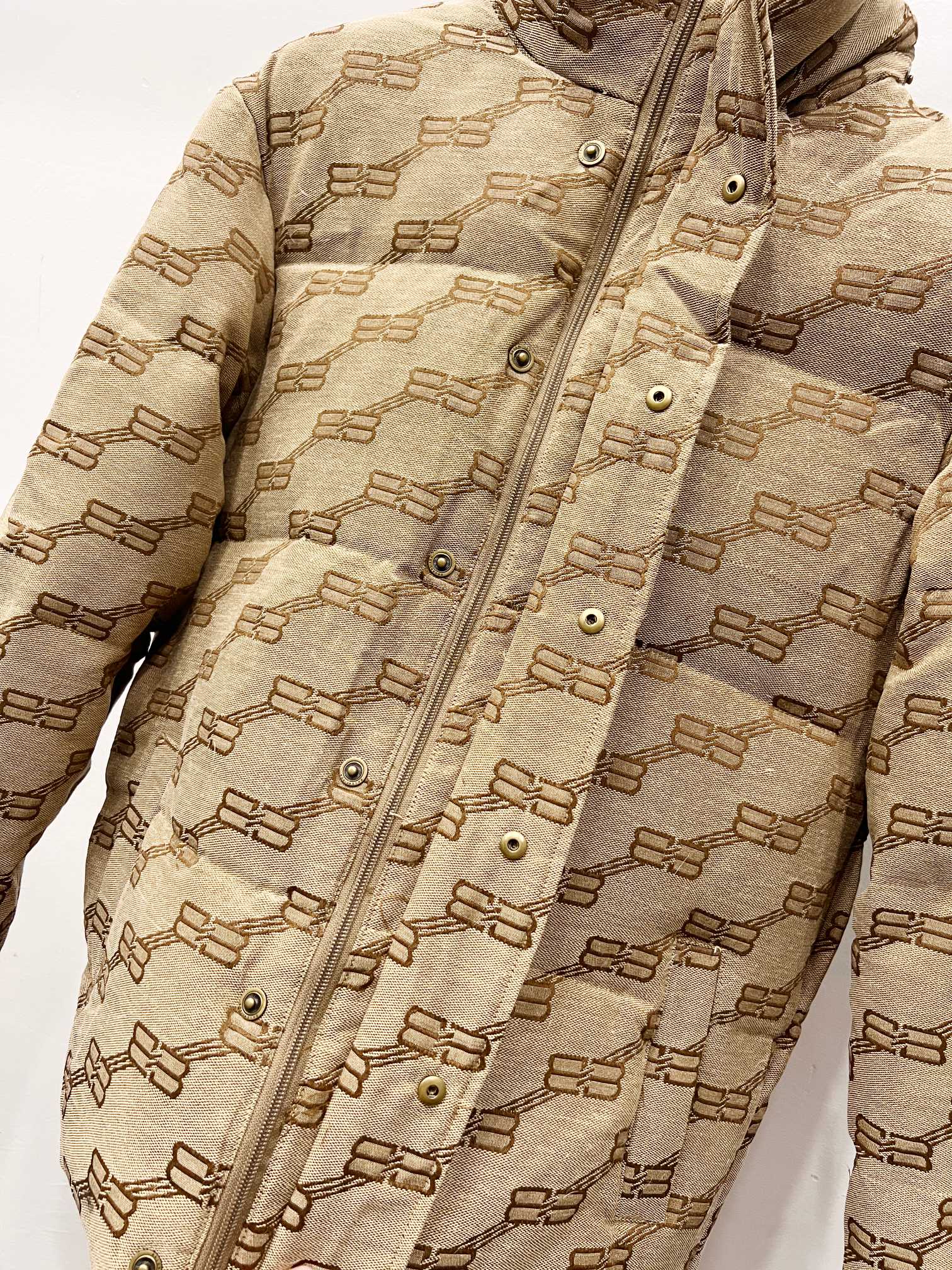 Balenciaga hooded puffer jacket in beige with repeating logo pattern, snap placket details
