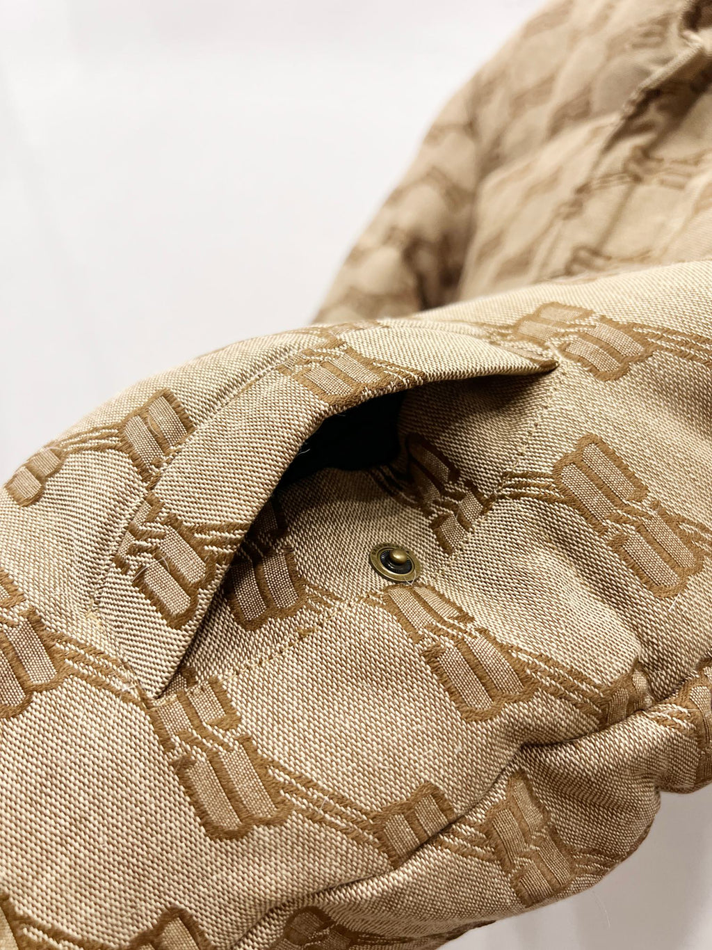 Balenciaga puffer jacket sleeve cuff in beige with repeating logo pattern and button