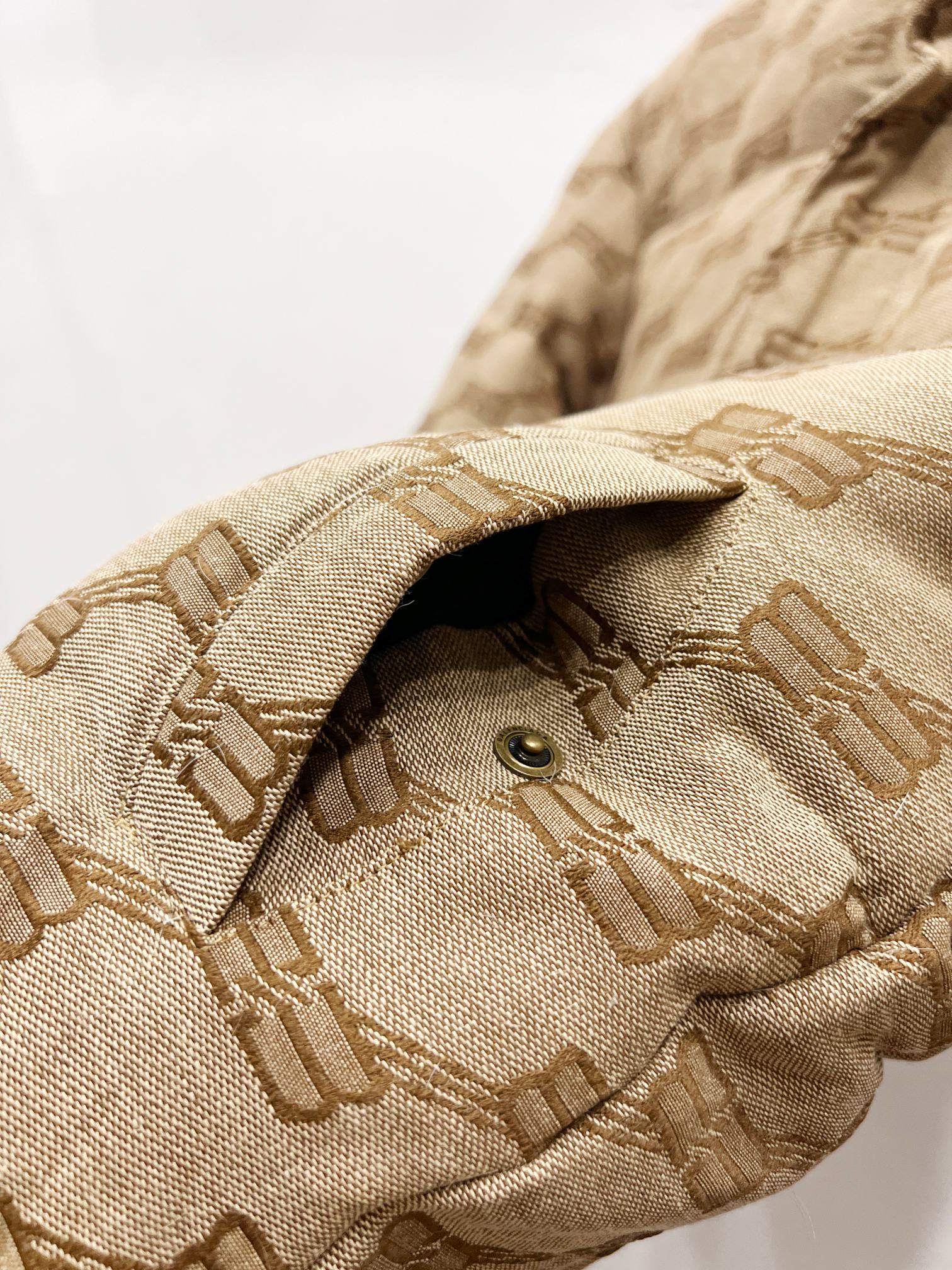 Balenciaga puffer jacket sleeve cuff in beige with repeating logo pattern and button