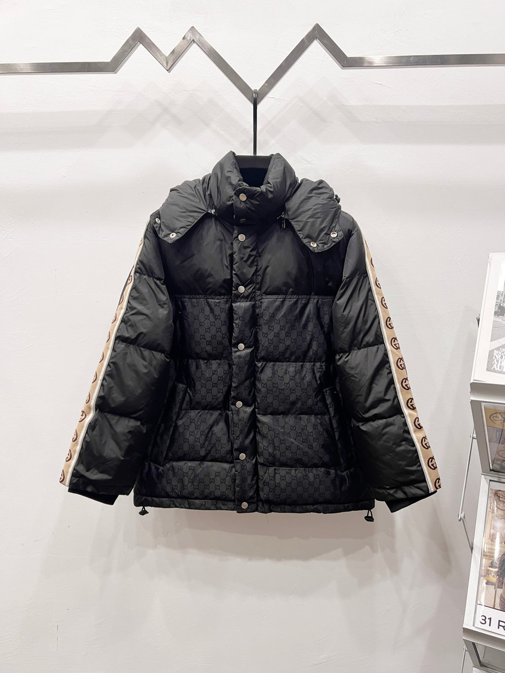 Dark long puffer jacket with hood, button front, and quilted panels