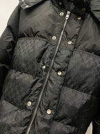 Dark puffer jacket front with zipper, snap buttons, and monogram pattern