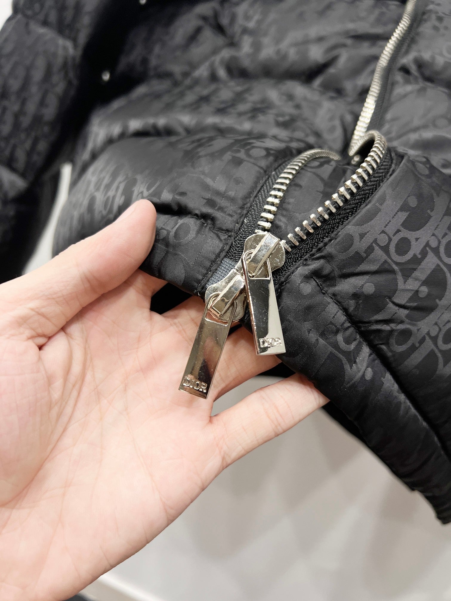 Quilted puffer jacket close-up of zipper pull and stitching