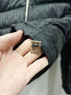 Quilted puffer jacket close-up with metal brand tag and zipper